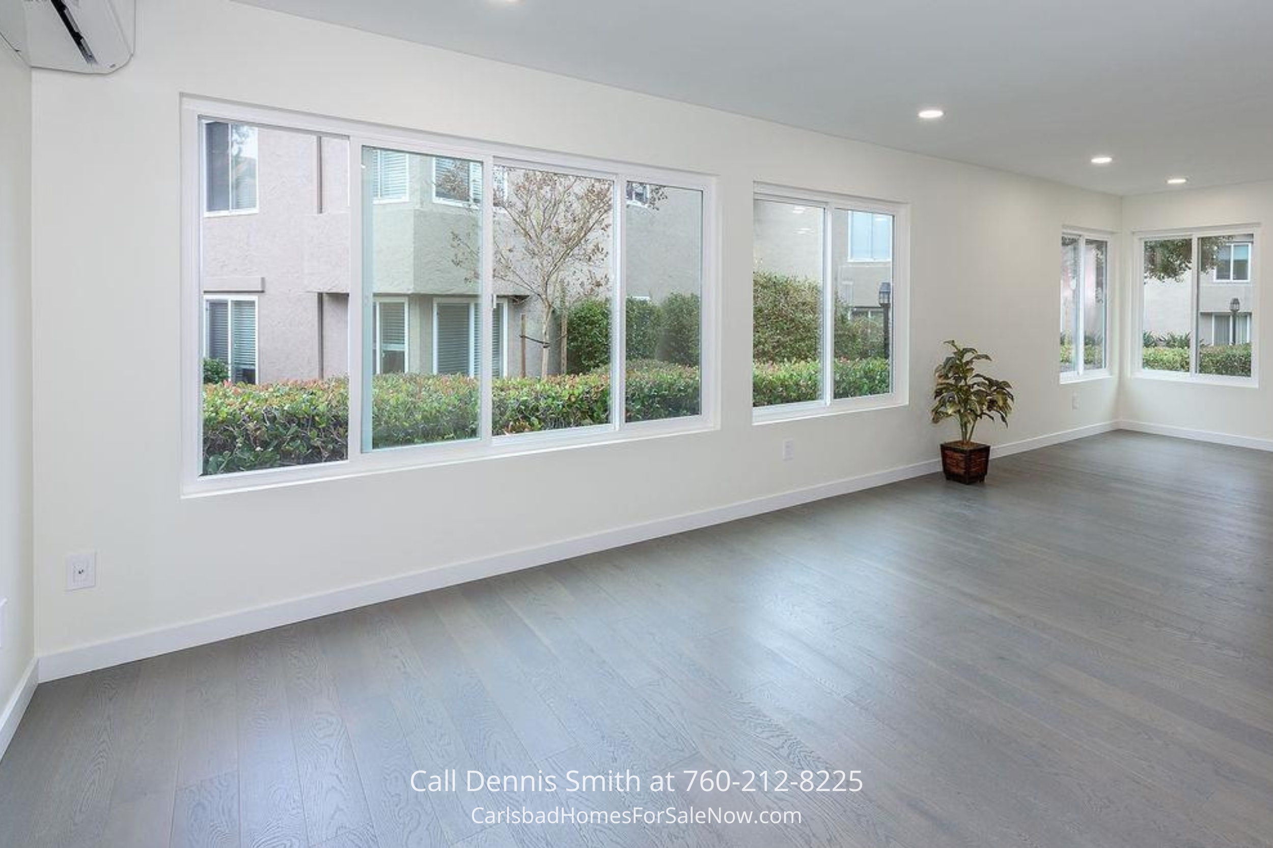 Spacious living area with large windows, wood-style flooring, and ample natural light at 930 Via Mil Cumbres Unit 175 Solana Beach condo.