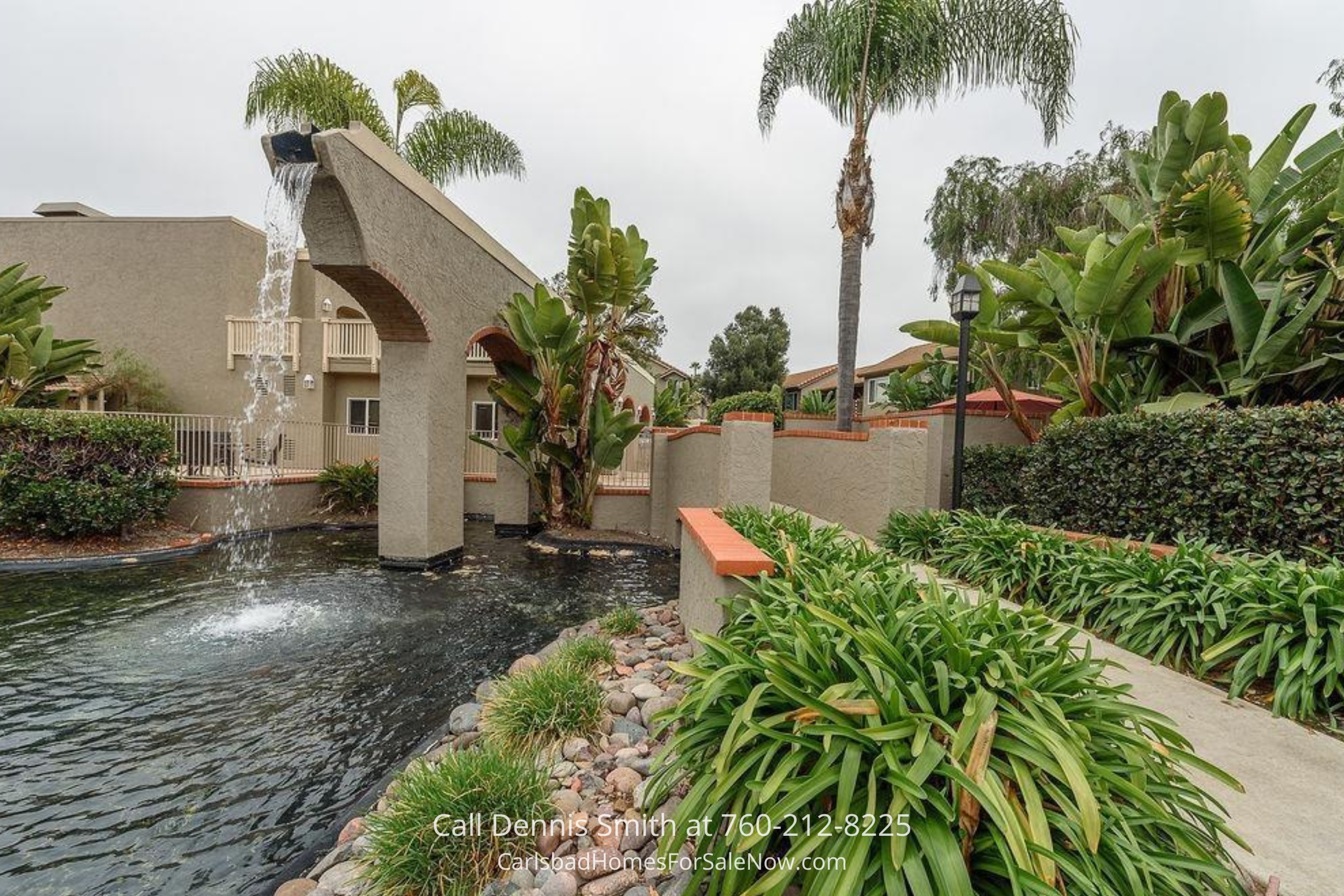 Beautiful outdoor courtyard with vibrant landscaping and a tranquil water feature at 930 Via Mil Cumbres Unit 175 Solana Beach community.